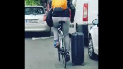 man rides down street with bike