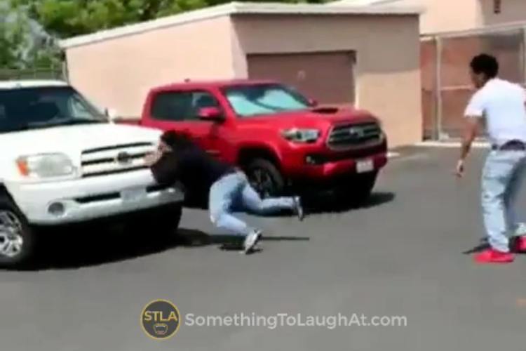 A guy runs into a car while playing football