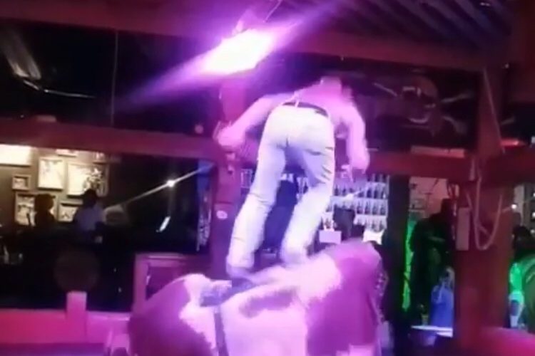 Man stands up on bull ride