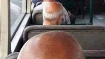 bald men sitting behind each other on bus