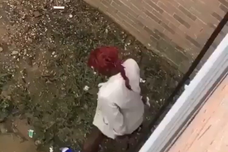 Woman poops on side of apartment complex