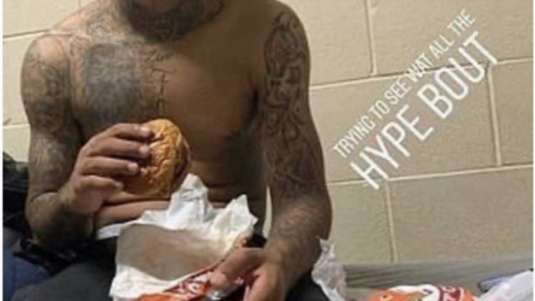 Inmate eating Popeyes sandwich in jail