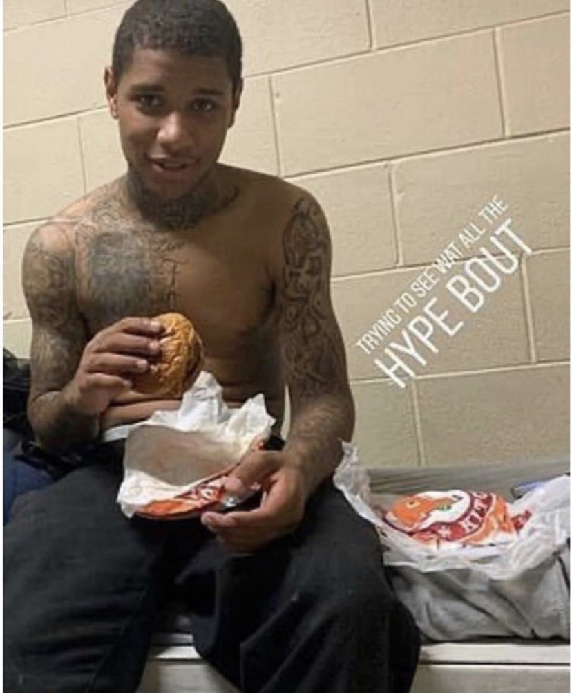 Inmate eating Popeyes sandwich in jail