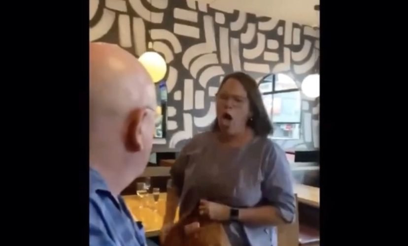 Angry woman coughs on man in restaurant