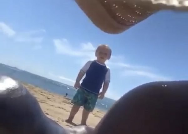 Little boy staring at women on beach