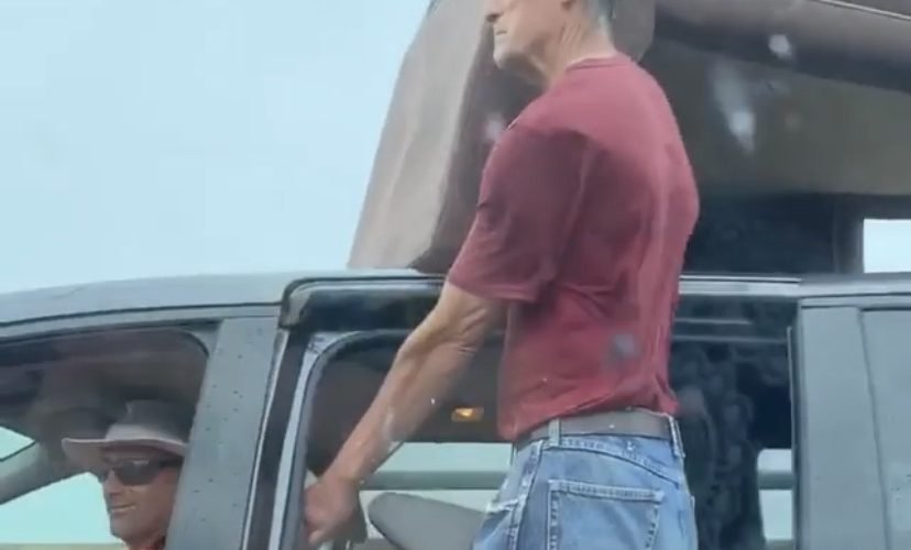 Man holds furniture on top of car