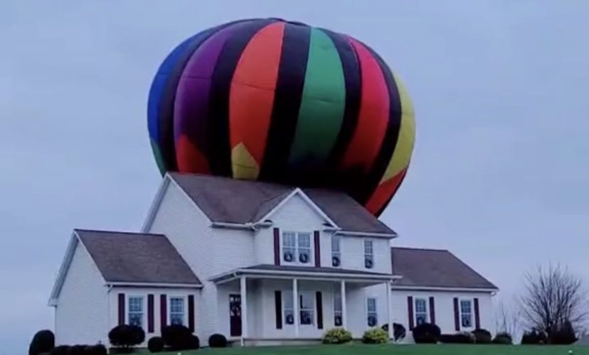 Hot air balloon lands on house