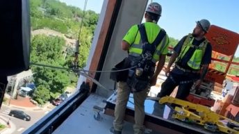 Construction workers screw up window install