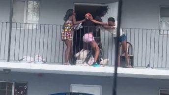 Women fight on a complex's balcony