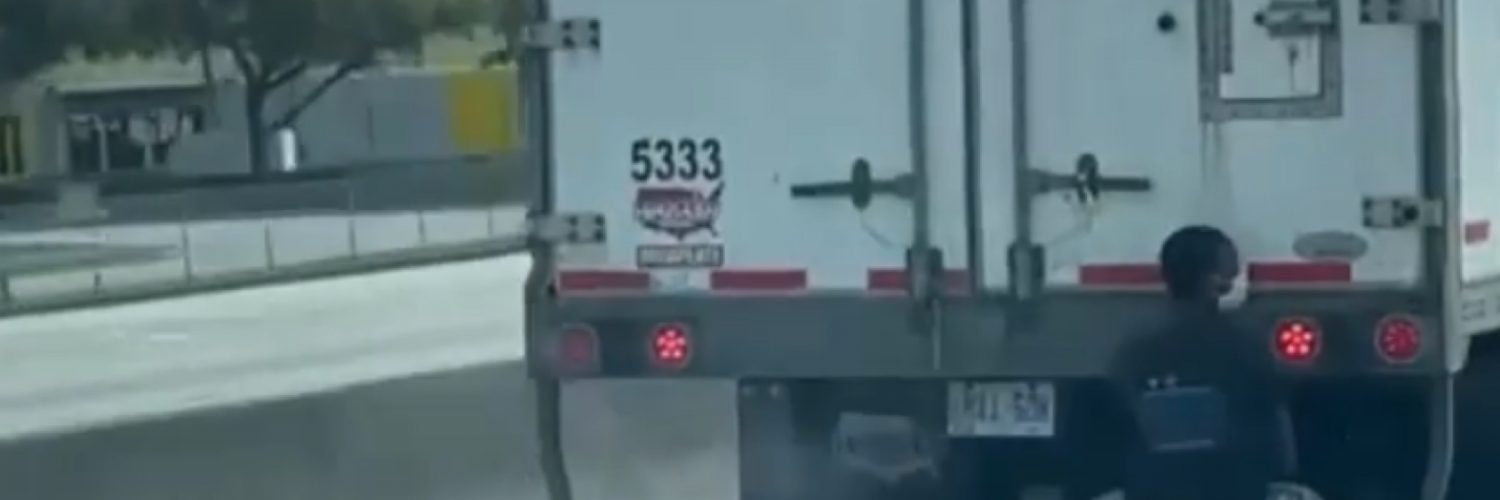 Man caught hitching a ride on the back of an 18 wheeler