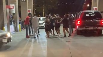 People dance in the middle of a gas station